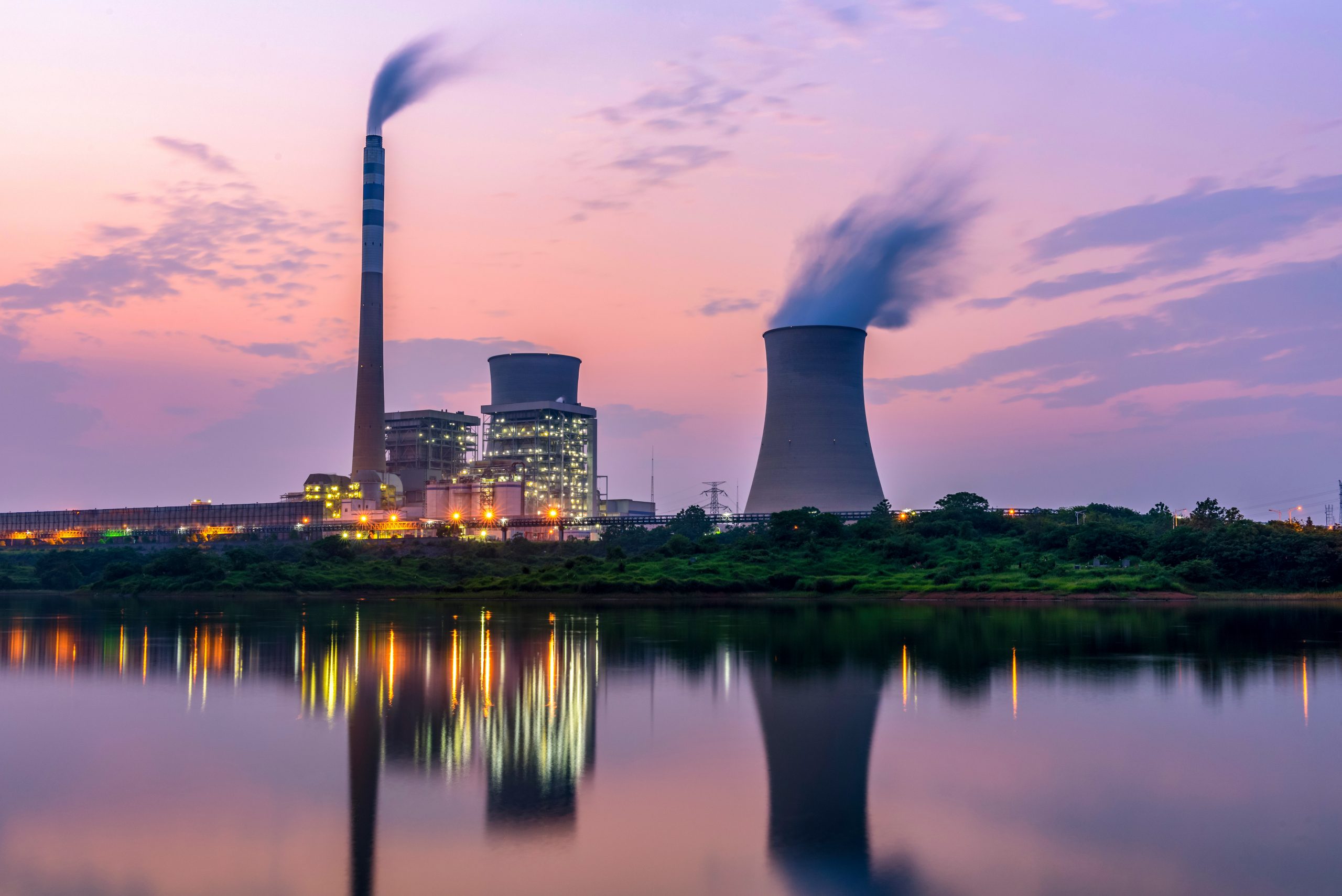 Efficient thermal power plant with advanced Air Quality Control by MET reflected in water at dusk, meeting 21st-century emission standards.