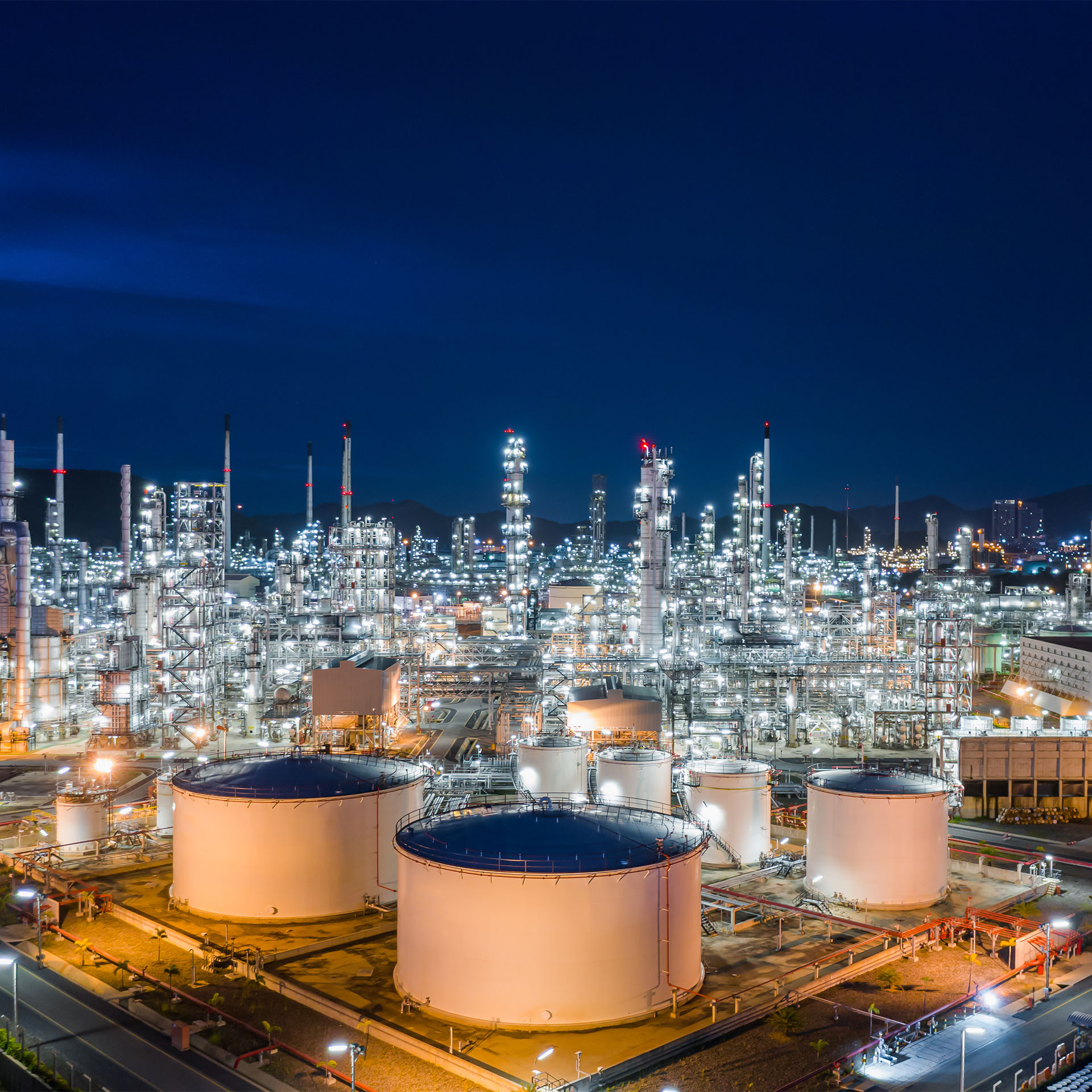 Illuminated industrial plant at night showcasing MET's advanced Limestone/Gypsum WFGD system, highlighting decades of expertise in sustainable emission reduction.