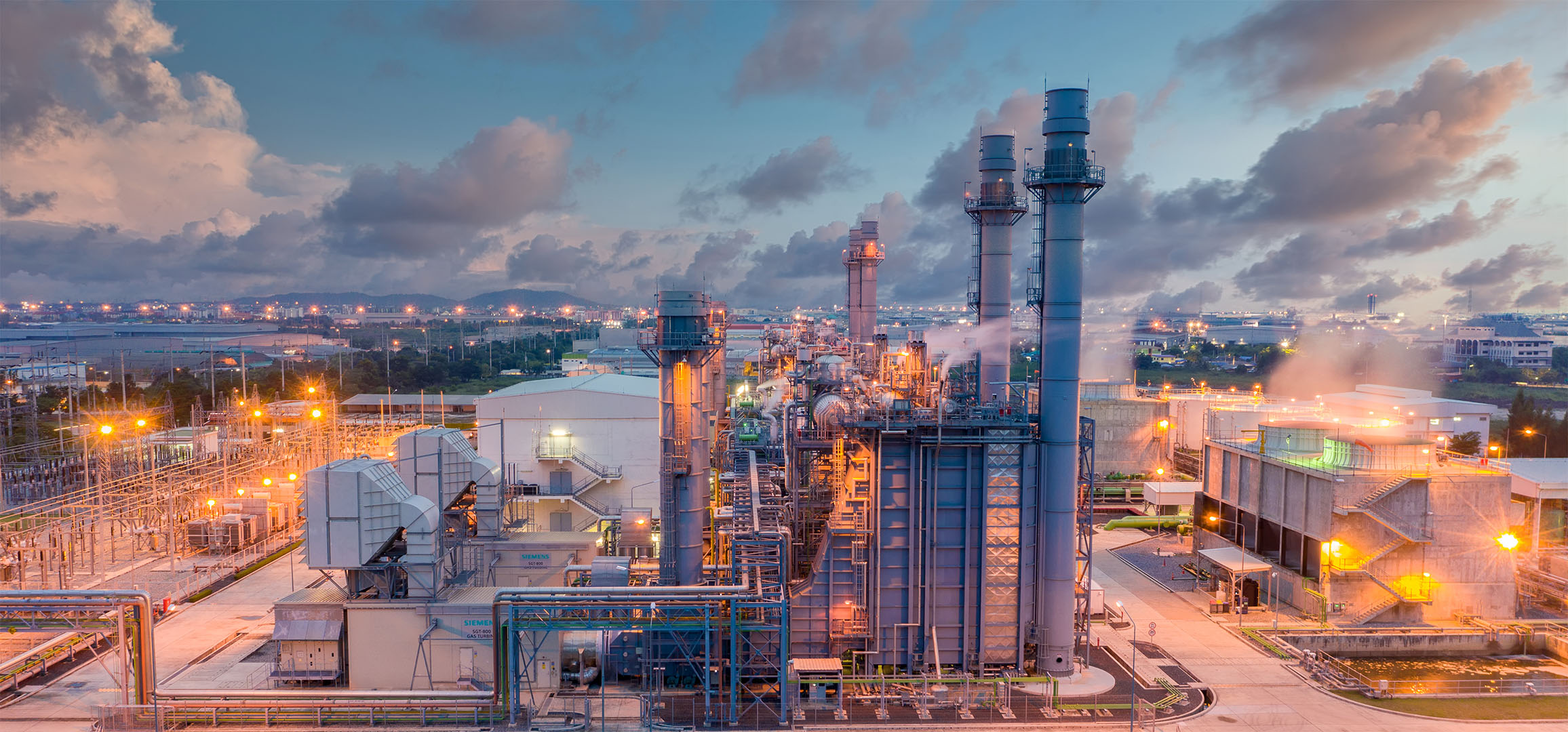 An industrial power plant at dusk showcasing Marsulex Environmental Technologies' AS WFGD system that converts SO2 into eco-friendly fertilizer, enhancing sustainability.